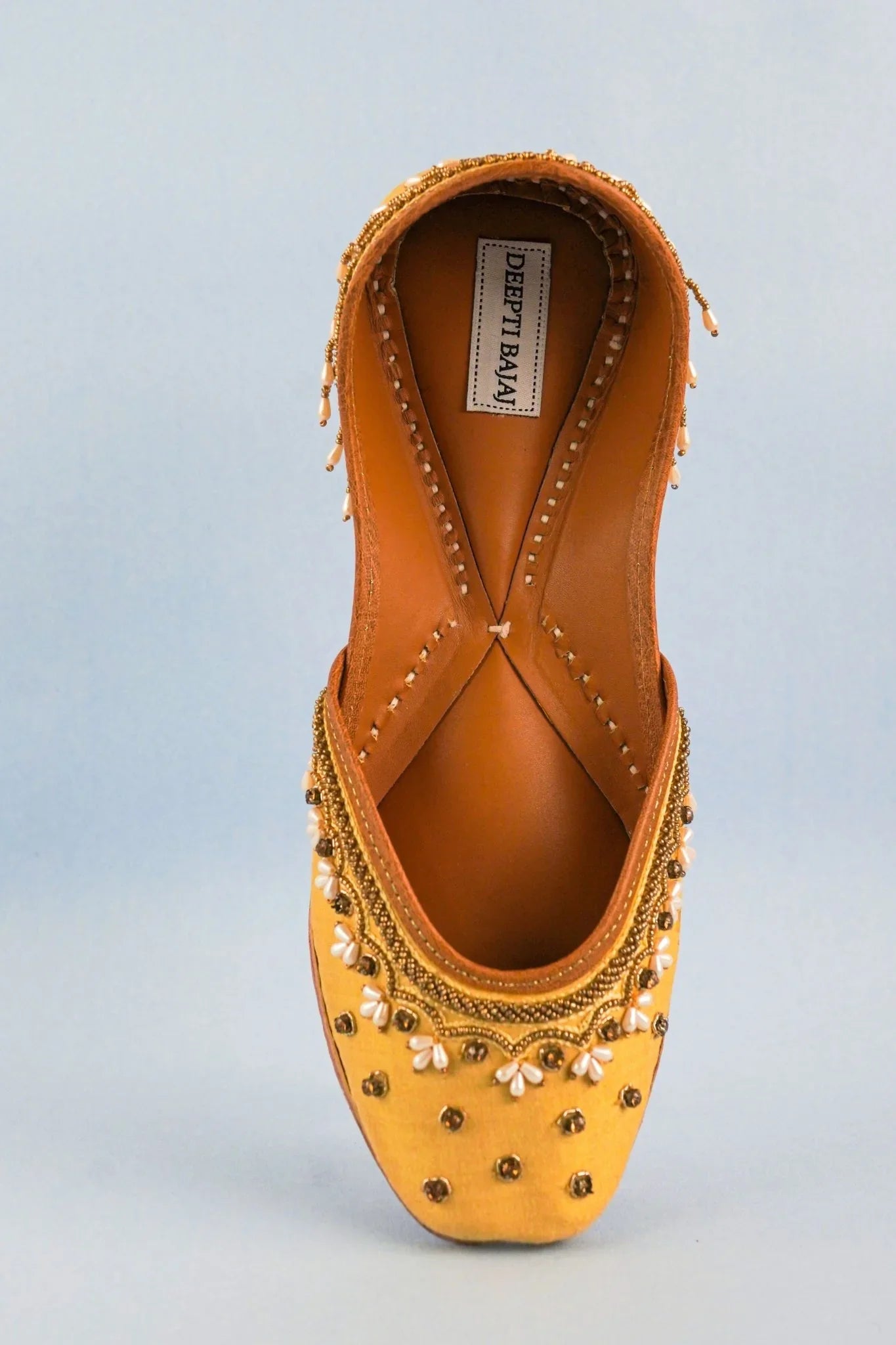 Top view of handcrafted yellow jutti for women with intricate bead and pearl embroidery from Label Deepti Bajaj