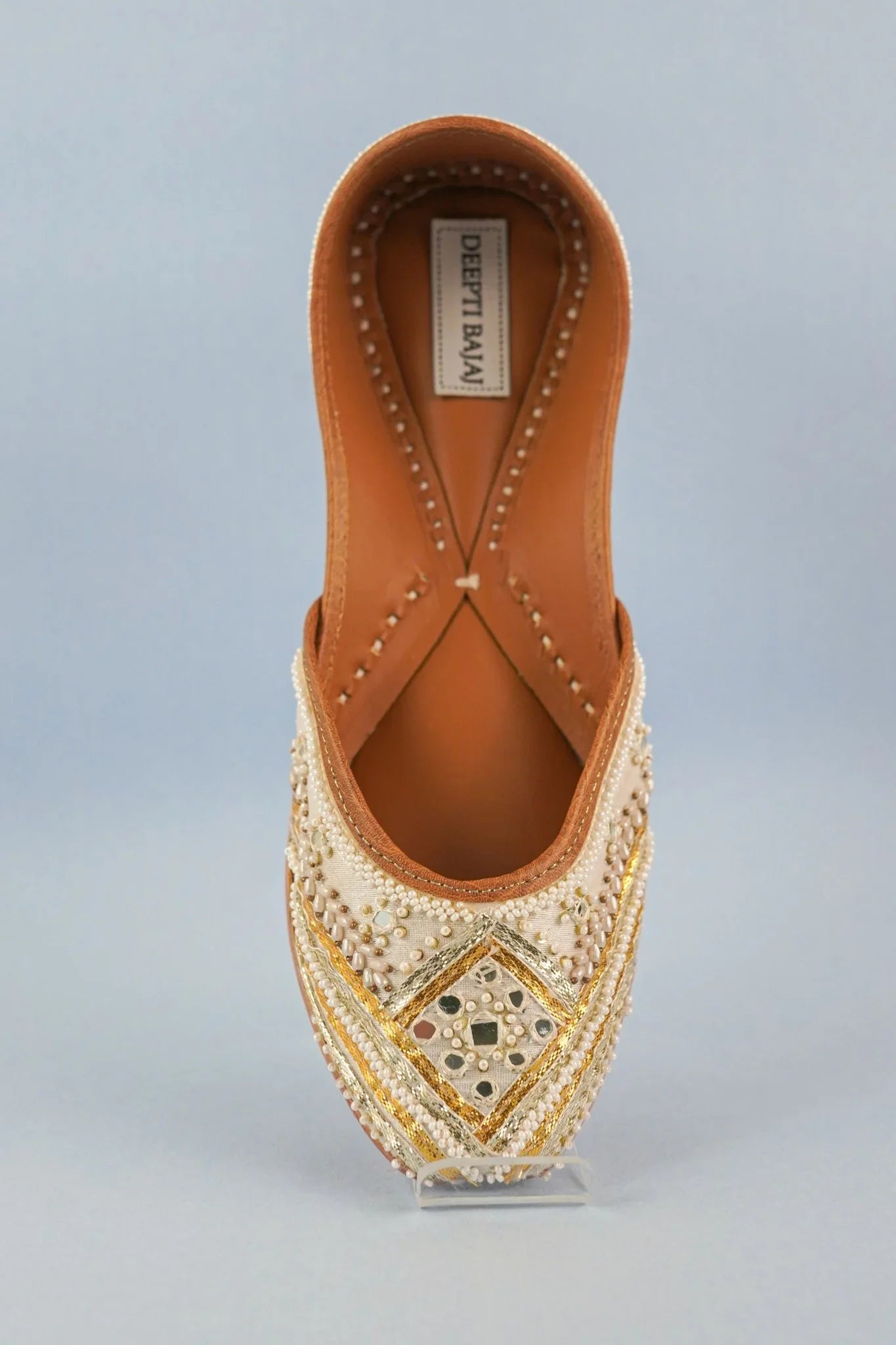 Handcrafted women's jutti by Deepti Bajaj with intricate pearl and gold bead embroidery on cream fabric
