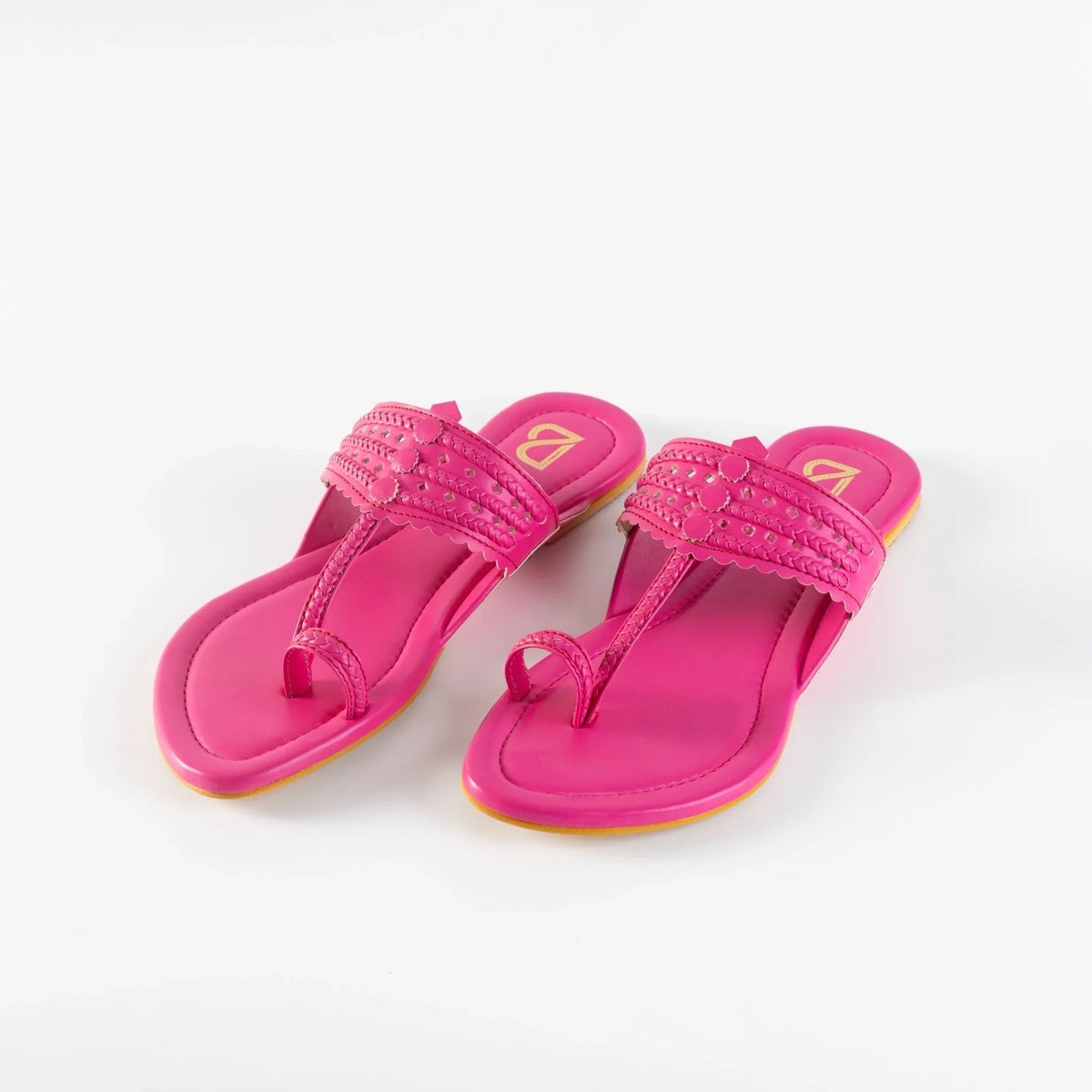 Bright pink women's handcrafted jutti sandals with braided and studded upper straps on white background