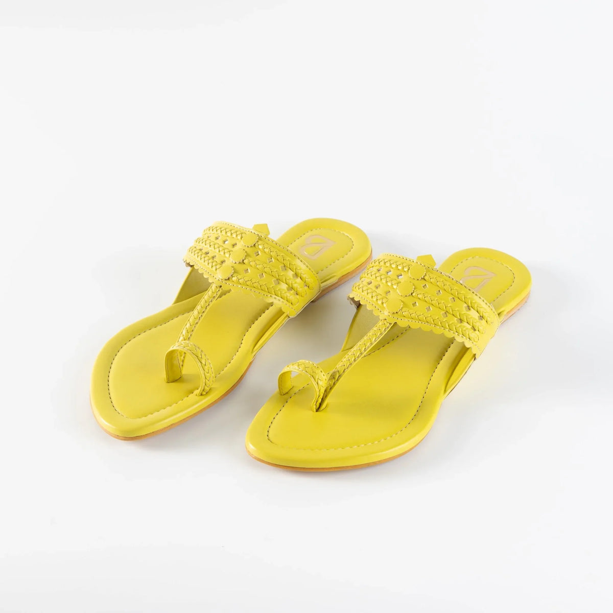 Yellow handcrafted women's jutti sandals with intricate braided and stitched detailing on white background
