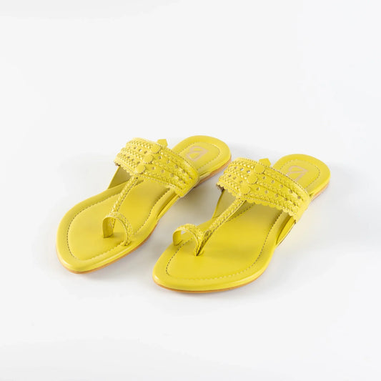 Yellow handcrafted women's jutti sandals with intricate braided and stitched detailing on white background