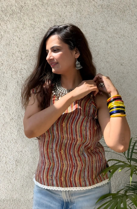 Simran: A woman with dark hair smiling, wearing a blue hijab and a beige abaya with subtle embroidery.